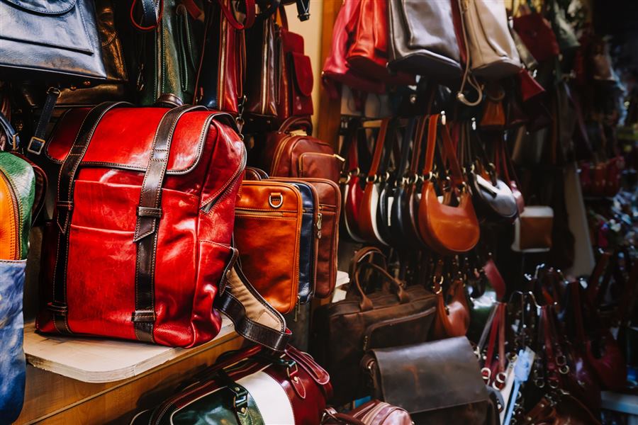A rich assortment of handcrafted leather bags in a quaint artisan shop.