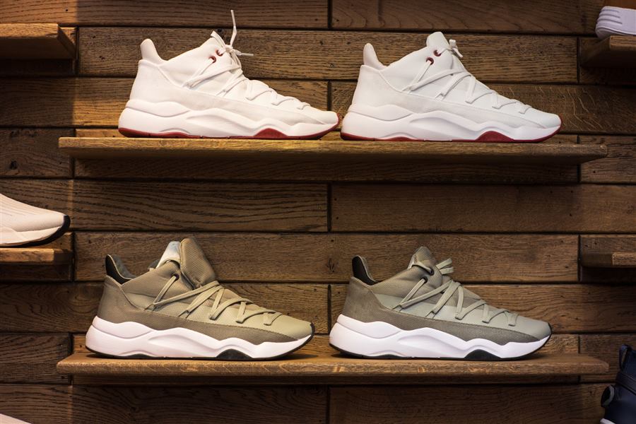 Modern sneakers showcased on wooden shelves in a stylish display setting.